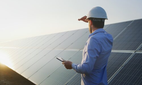 Person betrachtet Solarpanel